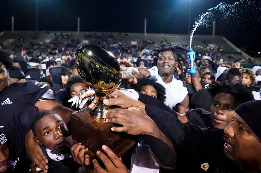 South Oak Cliff celebrates with the game trophy after a victory over Lubbock Cooper in a...