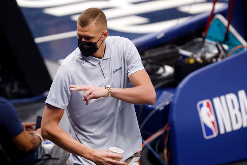 Kristaps Porzingis waves to friends as he steps into the arena during the first half of a...