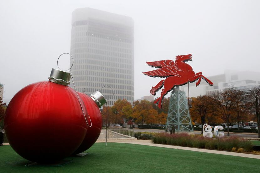 The Omni Dallas Hotel display large Christmas ornaments, left, and the Pegasus sign as fog...