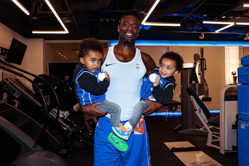 Mavericks wing Reggie Bullock carries his twin sons, Heart and Soul, through American...