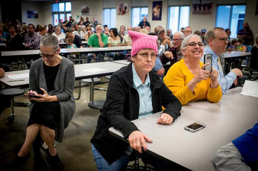 Lori Callais, a local resident wearing a pink protest hat, listens to Sen. Bill Cassidy...