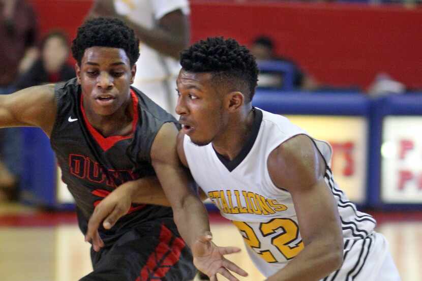 Triple A Academy senior King McClure (22, right) tries to drive past Bishop Dunne senior...