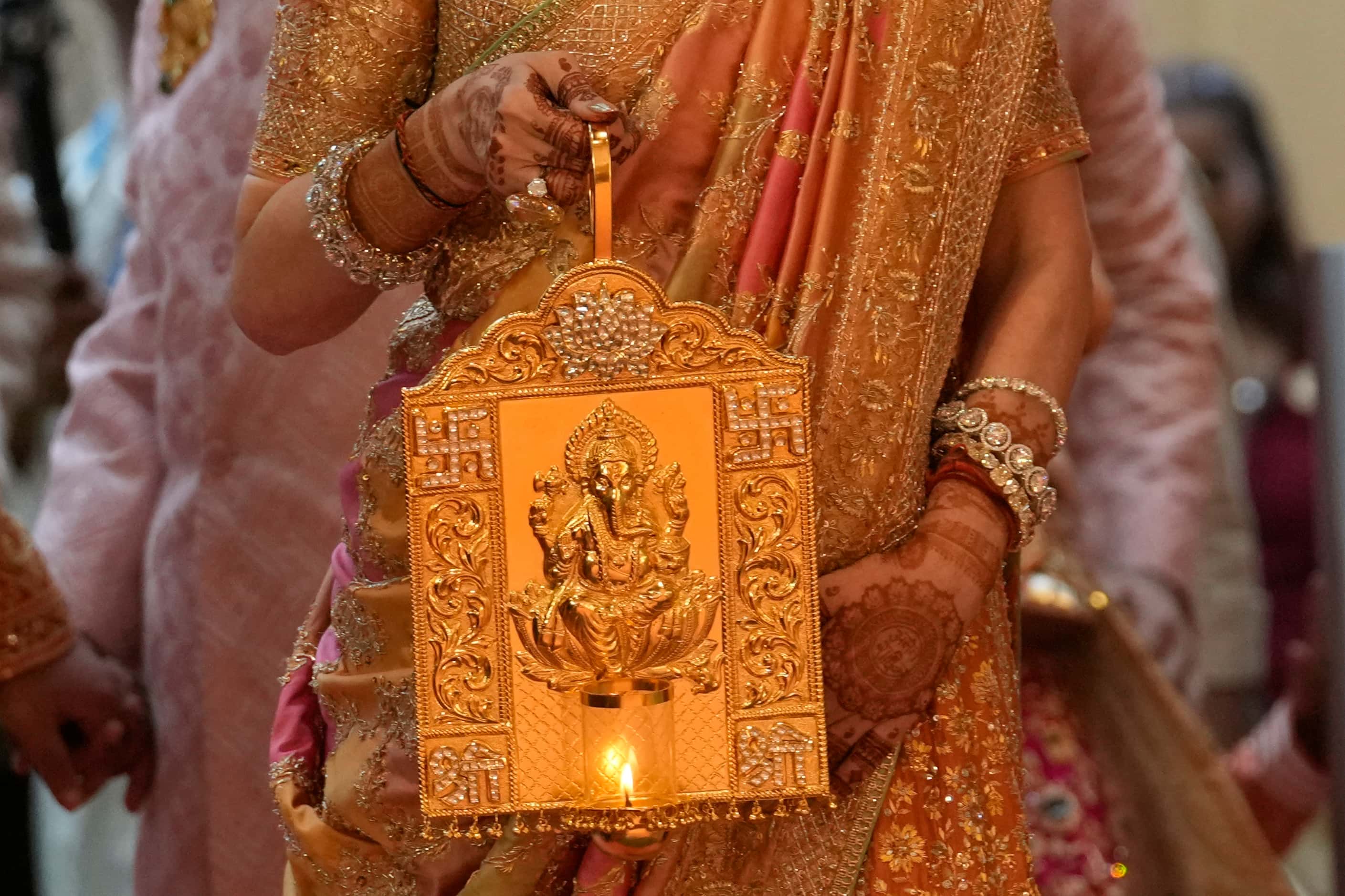 Nita Ambani, wife of Asia's richest man, Mukesh Ambani, arrives holding a lamp with an image...