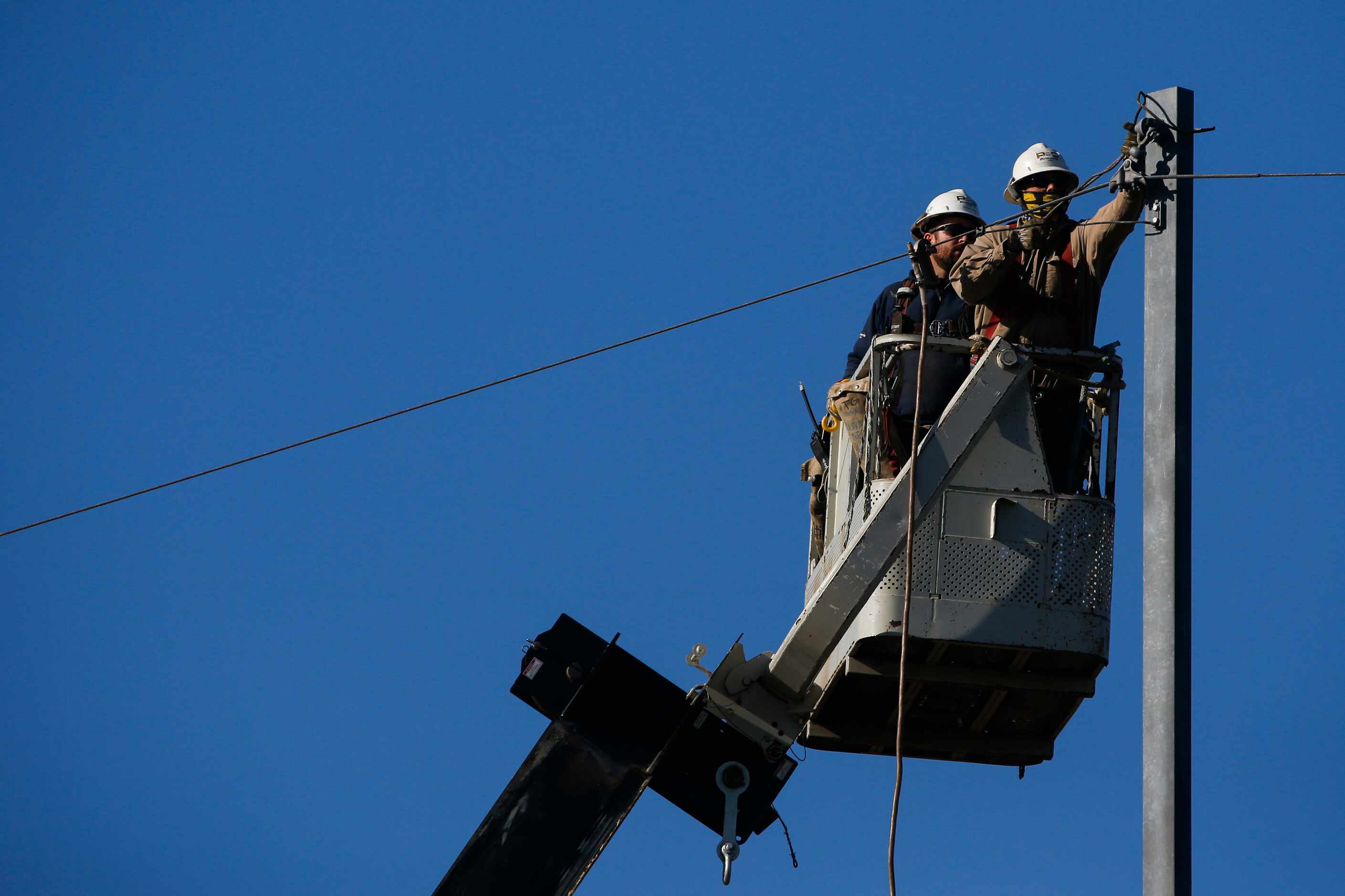 Power crews work after a tornado plowed through the area the night before near West Miller...