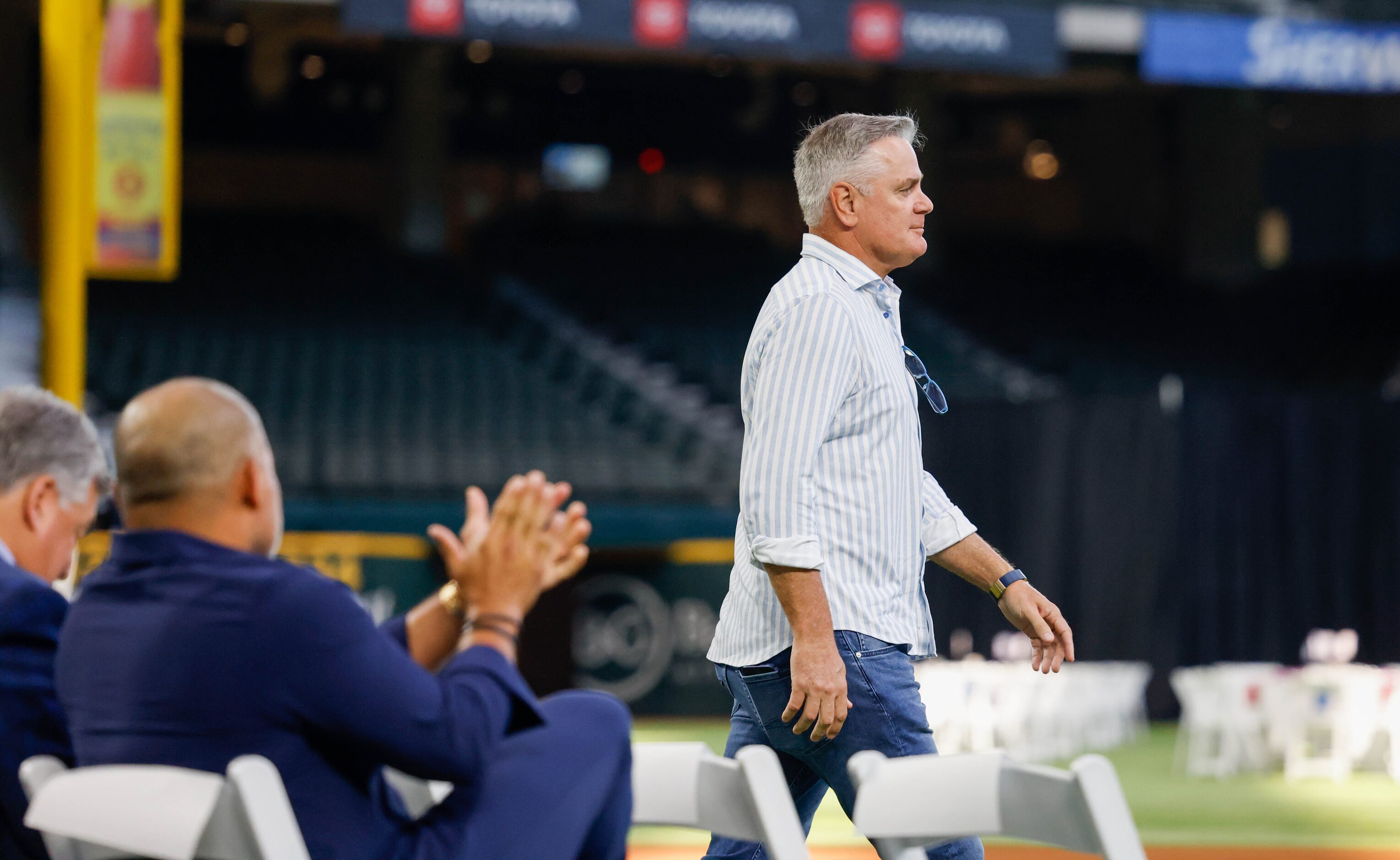 The audience claps as former Rangers pitcher Kenny Rogers (right) walks toward the stage to...