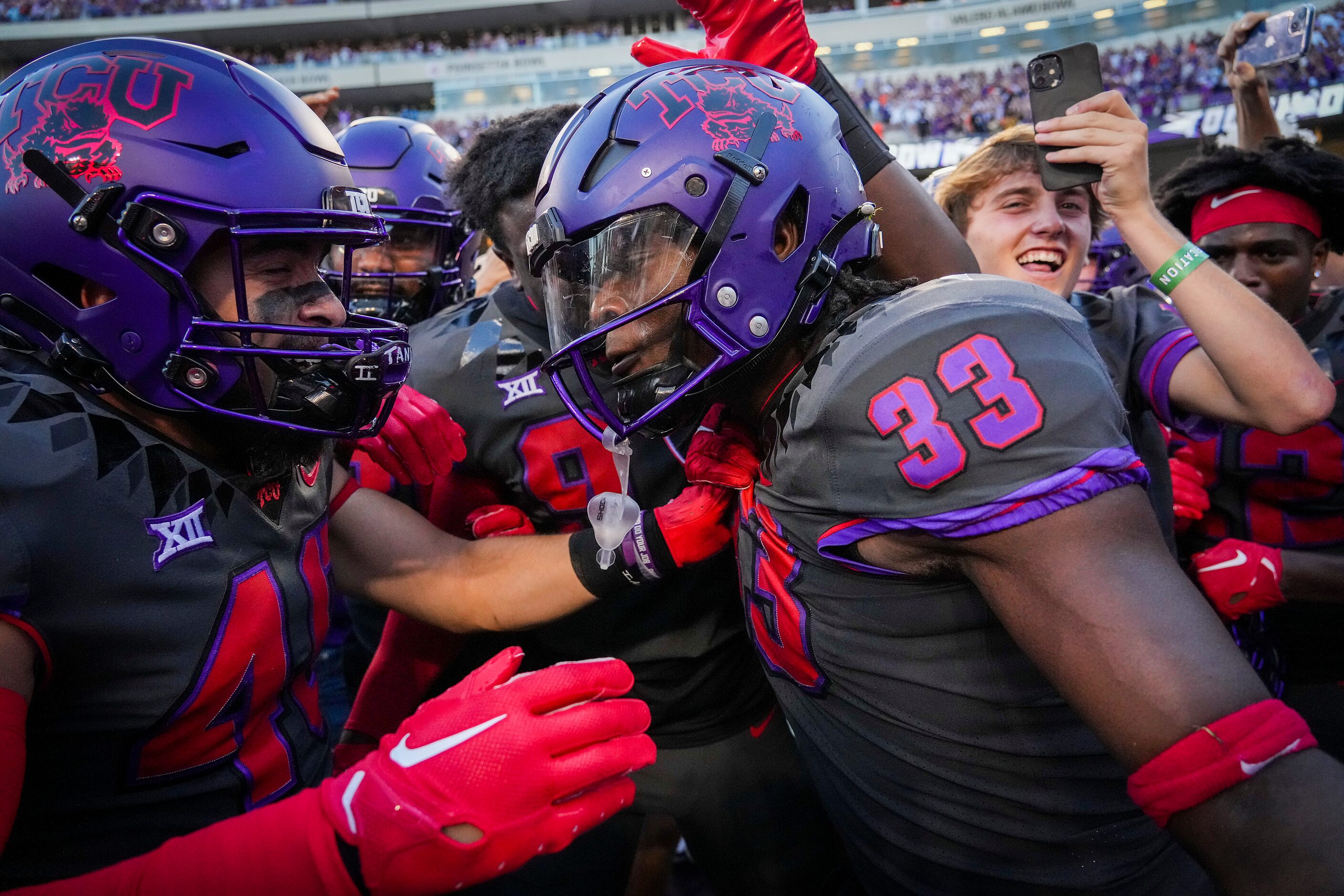 TCU running back Kendre Miller (33) celebrates with teammates and fans after scoring on a...