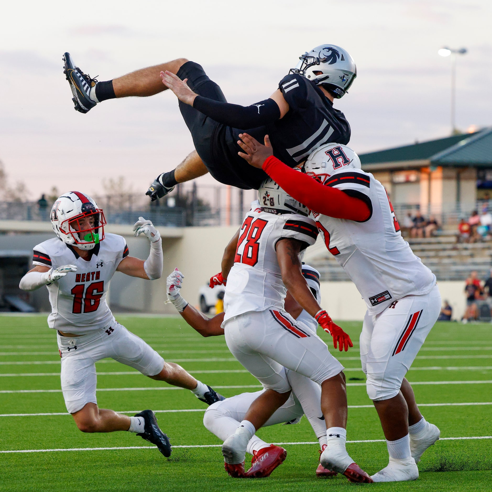 Denton Guyer quarterback Jackson Arnold (11) attempts to jump over Rockwall-Heath linebacker...