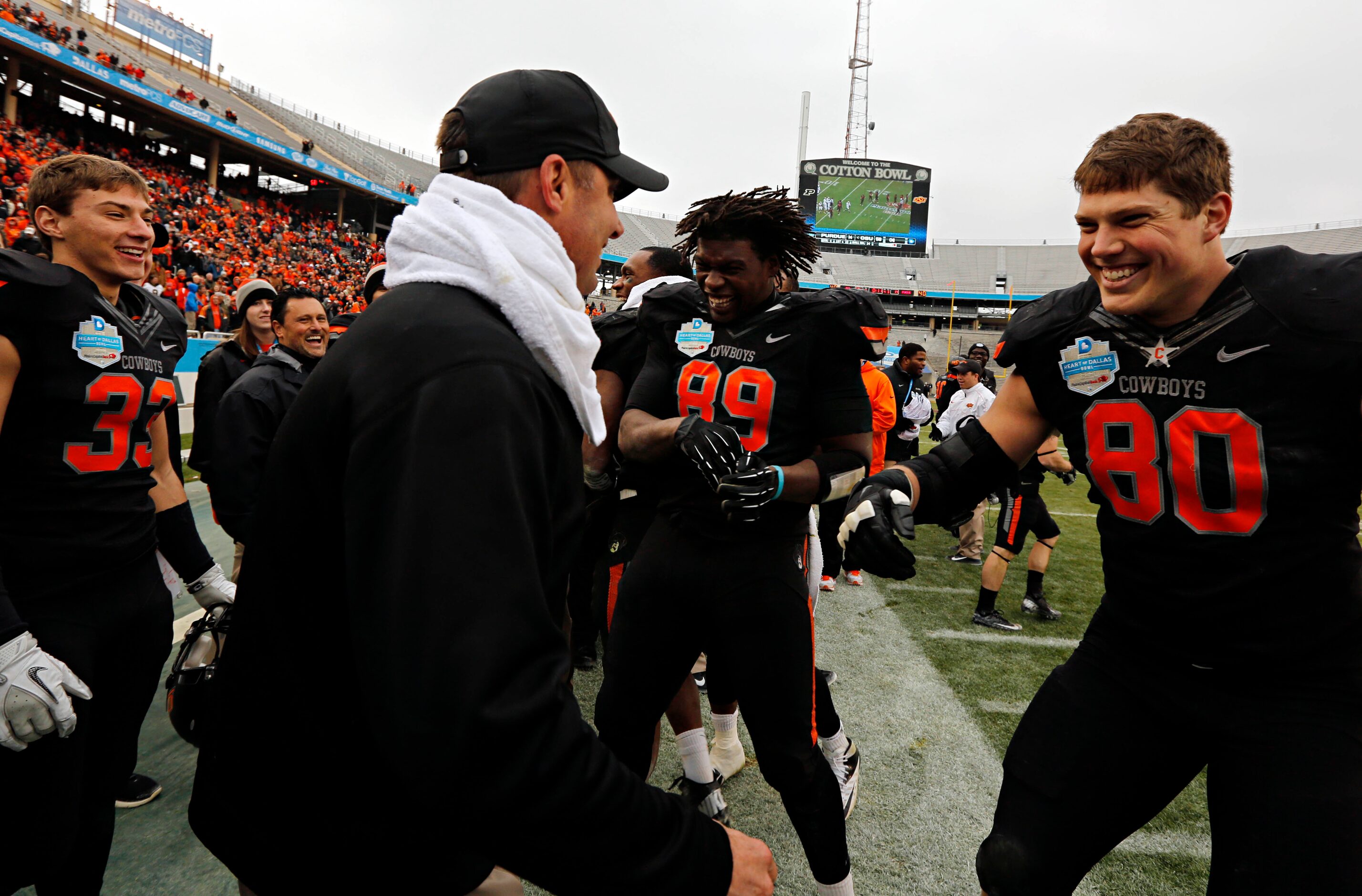 Oklahoma State Cowboys defensive end Cooper Bassett (80) celebrates with head coach Mike...