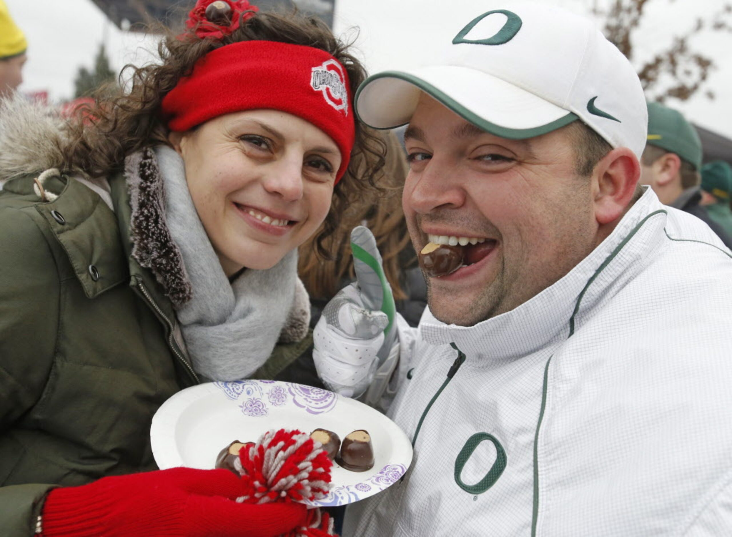 Ohio State fan Rachel Trotter  gives Oregon fan Josh Mc]Cleary a chocolate-covered buckeye...