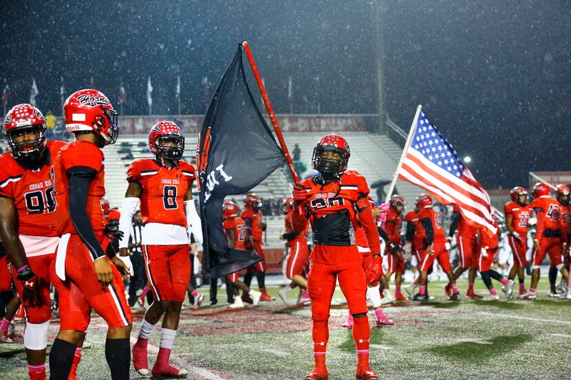 Cedar Hill High football players are introduced in the rain as they prepare to face...
