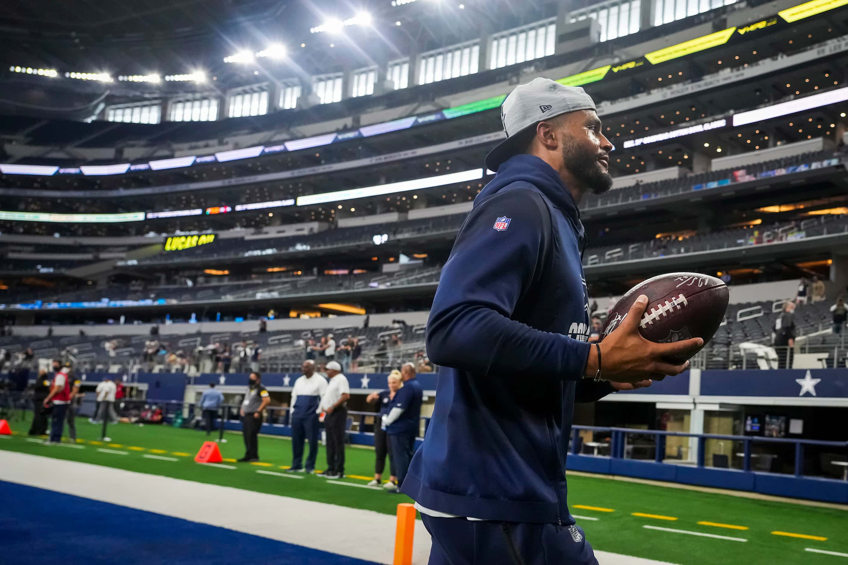 Dallas Cowboys quarterback Dak Prescott prepares to toss a ball to a fan as the team warms...