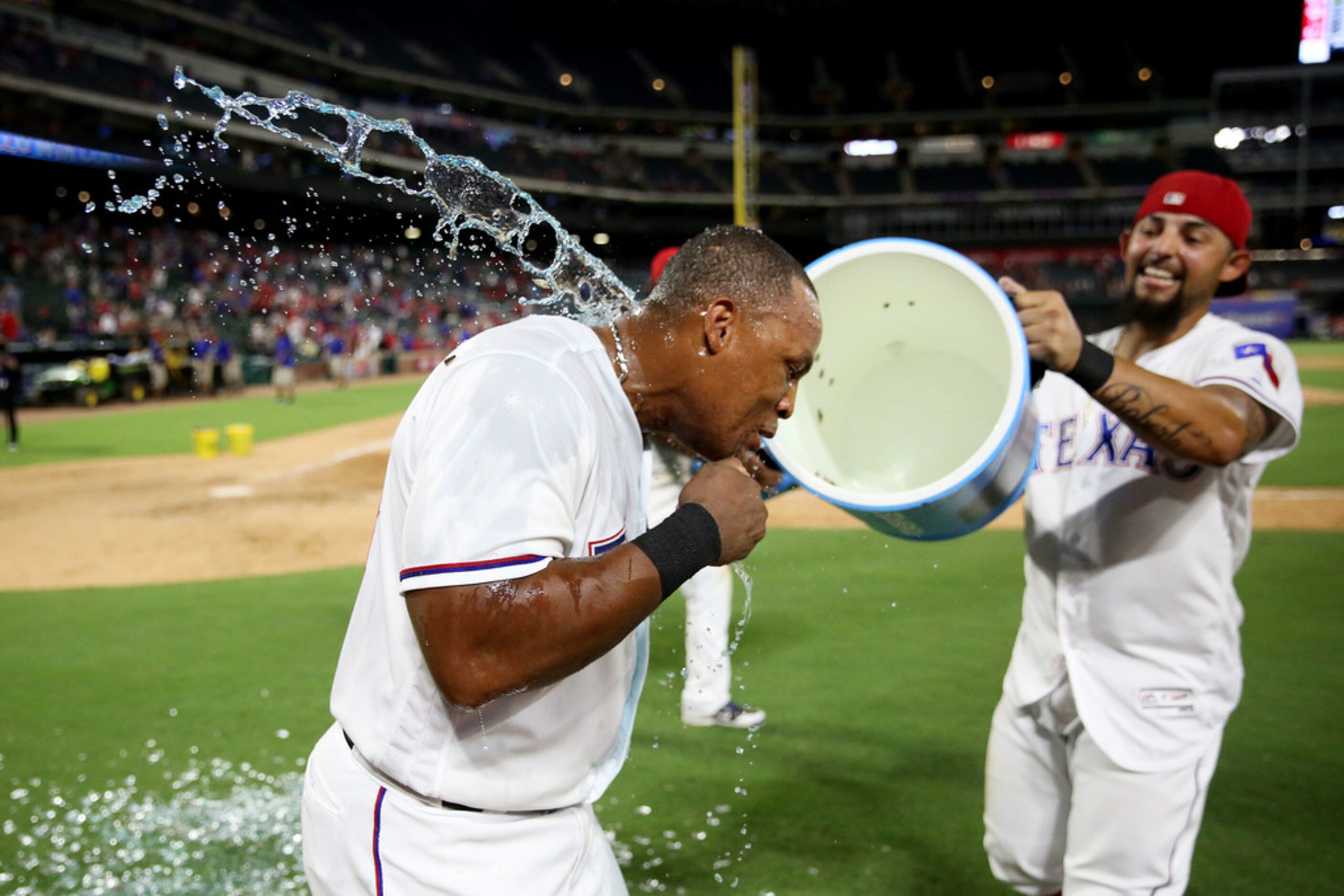 Texas Rangers third baseman Adrian Beltre (29) is doused by second baseman Rougned Odor (12)...