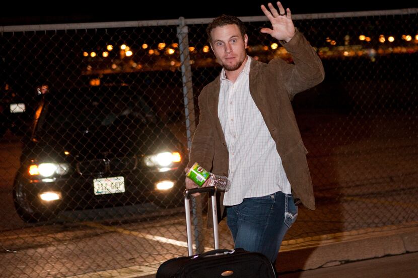 Josh Hamilton waves as the Texas Rangers were greeted by a small crowd of fans upon their...