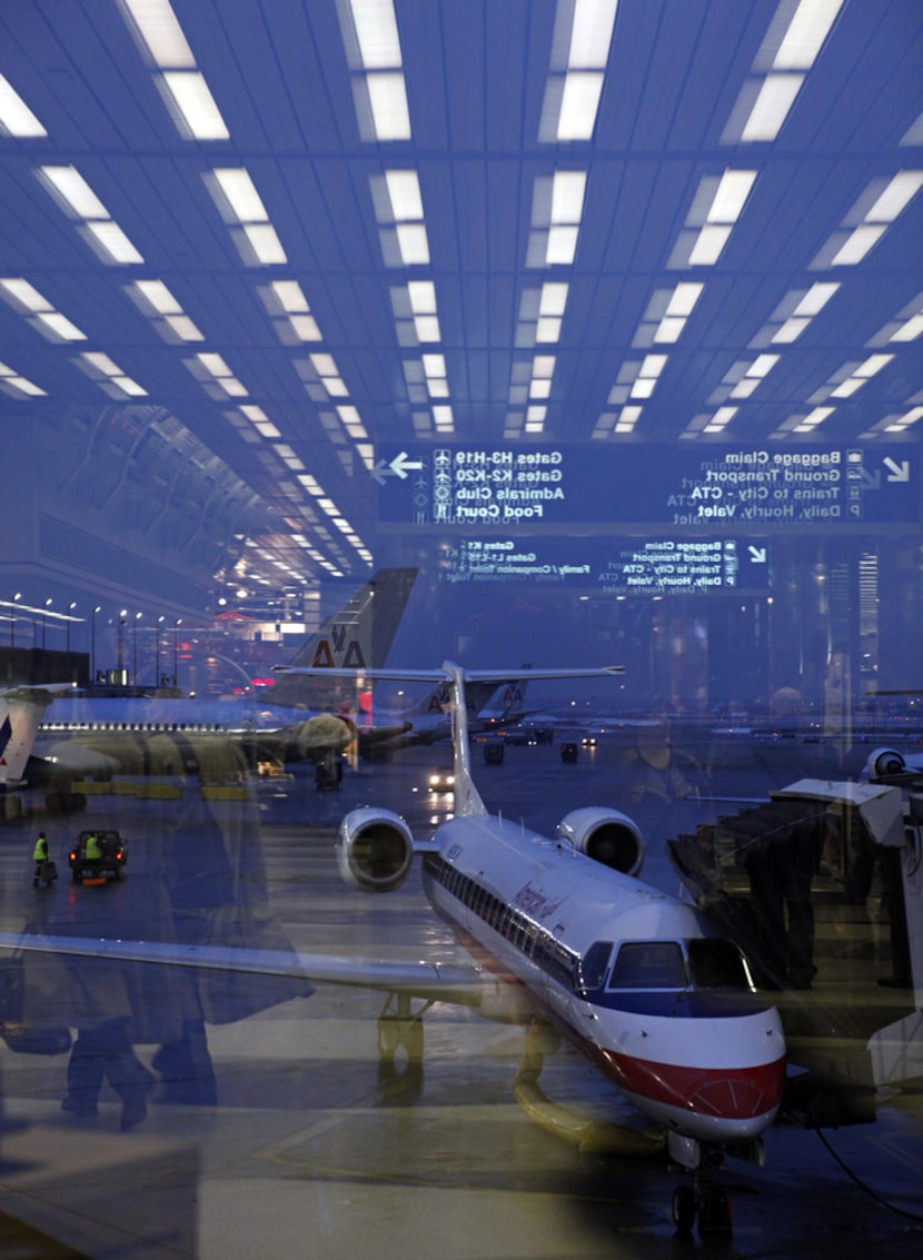 An American Eagle regional jet in front of larger American Airlines planes while the...