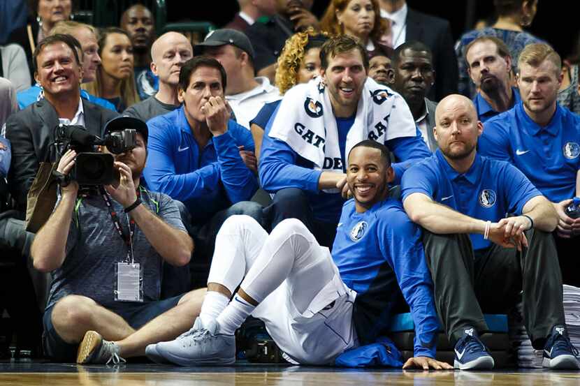 Mavericks forward Dirk Nowitzki (with towel around his neck) sits in the front row with team...