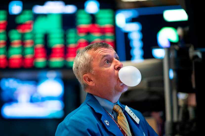A trader blows bubble gum during the opening bell at the New York Stock Exchange on Aug. 1.