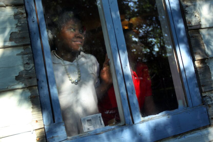 Brianna Gaut, 12, left, and Jeremiah Clewis, 8, watch as a scientist gathers soil samples...