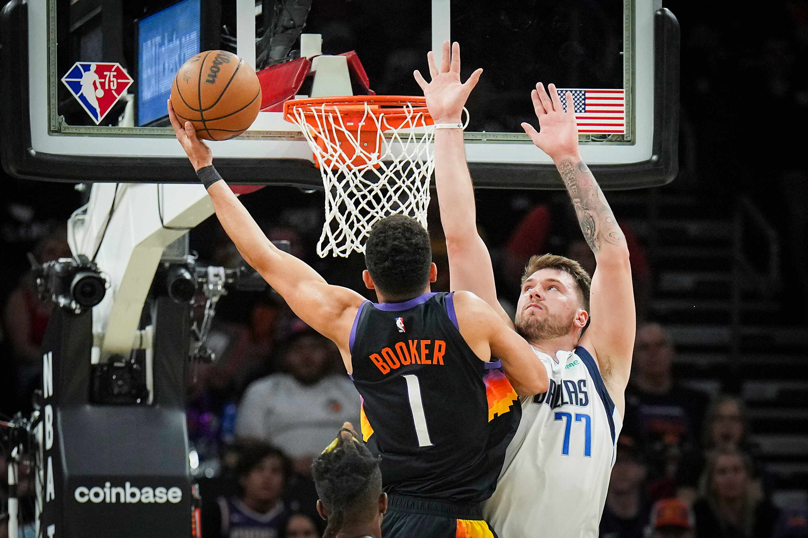 Dallas Mavericks guard Luka Doncic (77) defends a shot by Phoenix Suns guard Devin Booker...