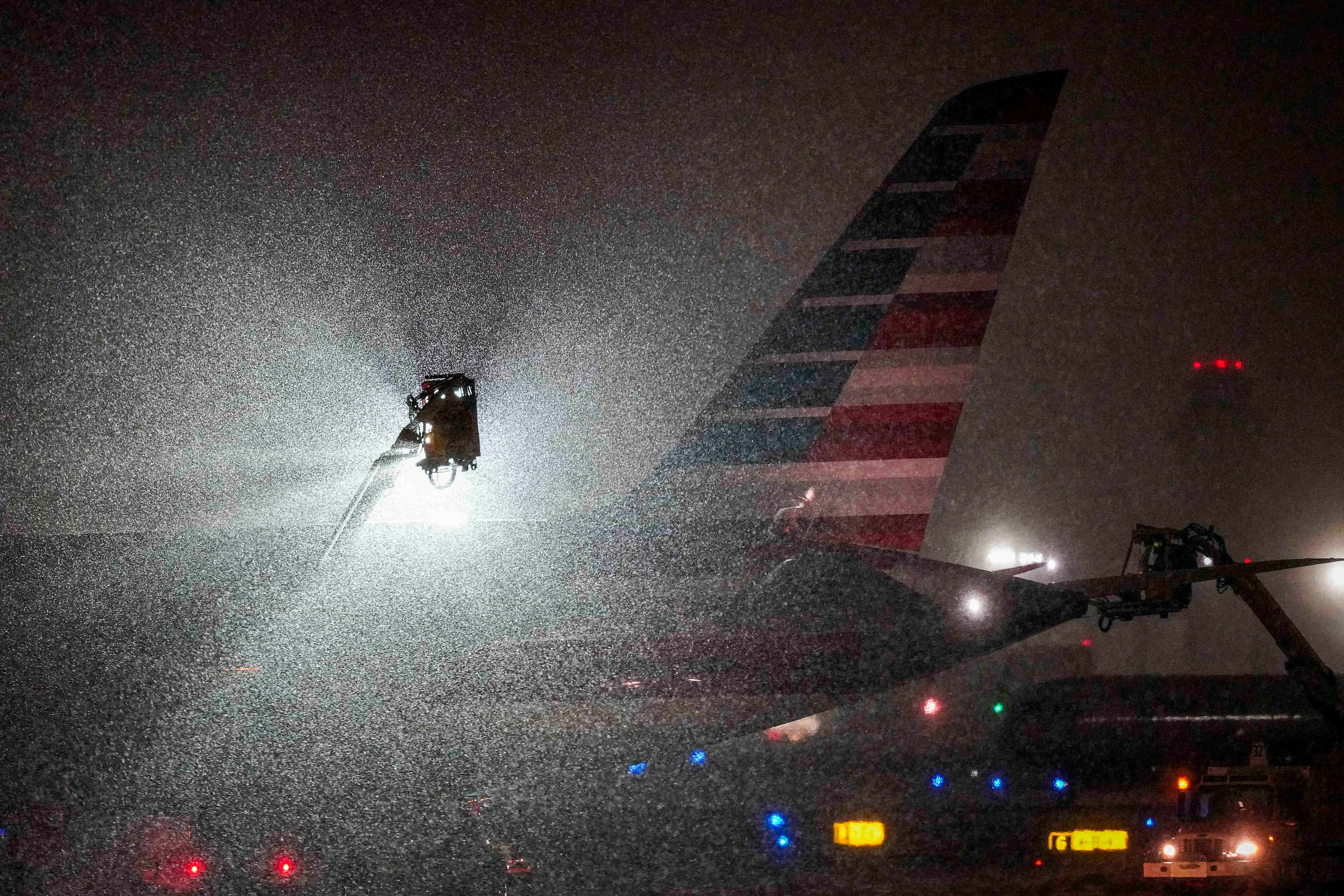 An American Airlines aircraft goes through deicing procedures as snow falls at DFW...