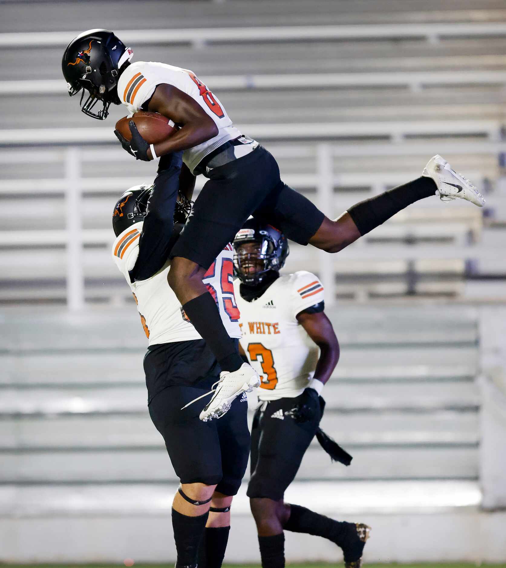 W.T. White wide receiver Demetrious Troupe (8) is hoisted into the air by lineman Anthony...
