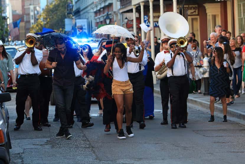 Nick Viall (left) and Rachel Lindsay (right) dance in a second line parade while on a date...