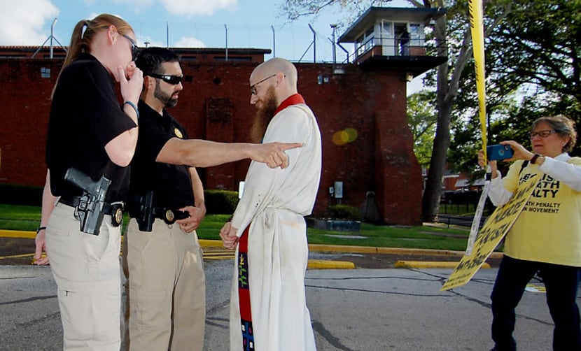  The Rev. Dr. Jeff Hood is confronted and arrested after crossing a police-tape barrier...