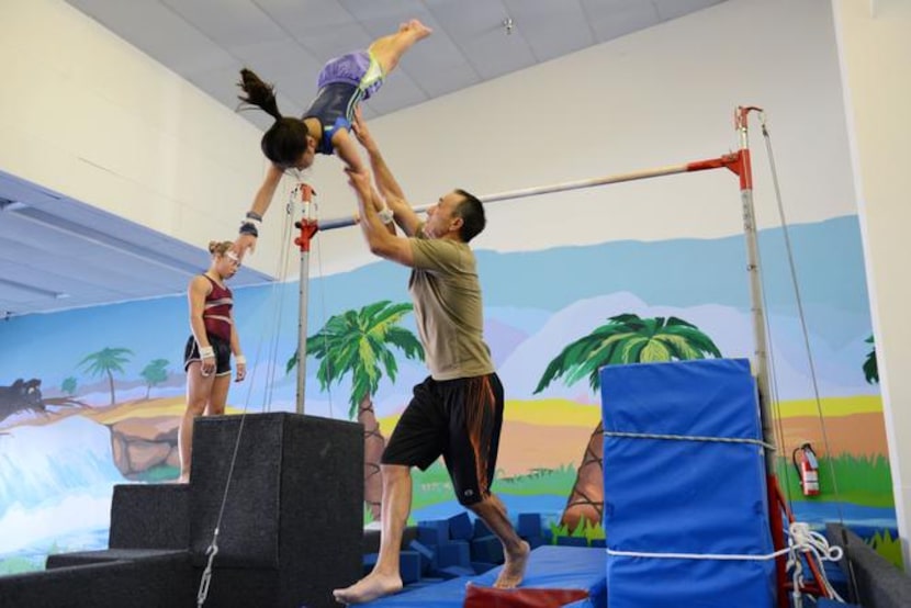 
Coach Eduoard Iarov spots Linda Tran, 10, on a landing during an afternoon practice at...