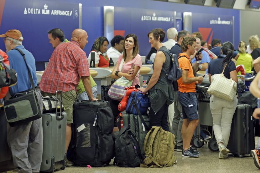 Passengers stand in line after Delta Air Lines flights resumed Monday in Salt Lake City,...
