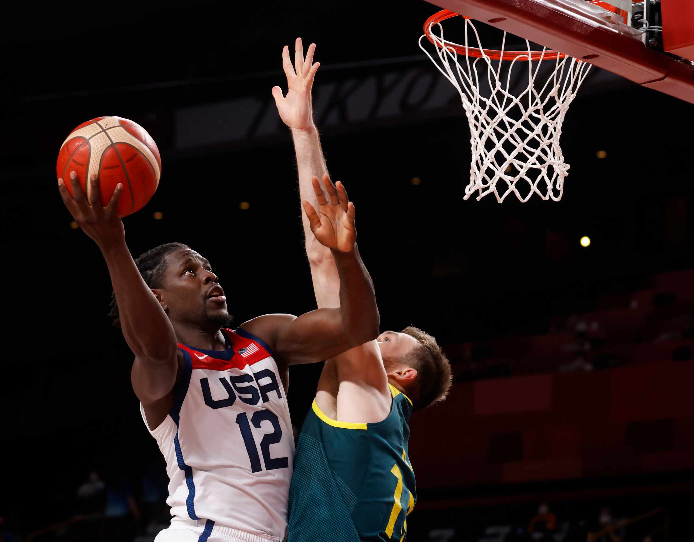 USA’s Jrue Holiday (12) attempts a shot in front of Australia’s Nic Kay (15) during the...