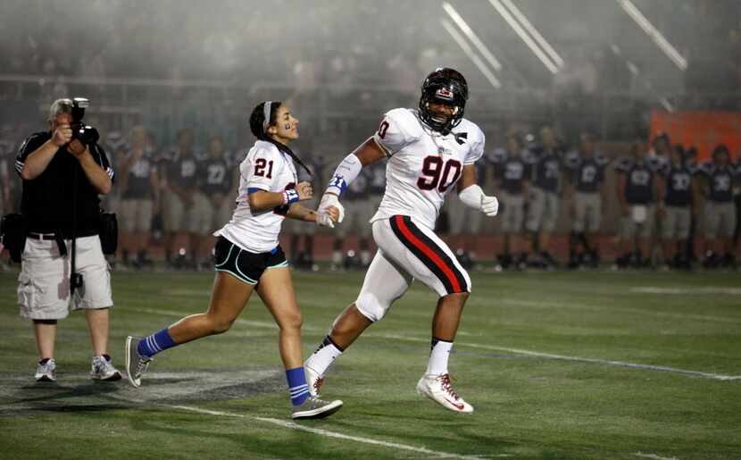 Coppell High School student Jordan Logan, sister of Jacob Logan, runs off the field with DL...