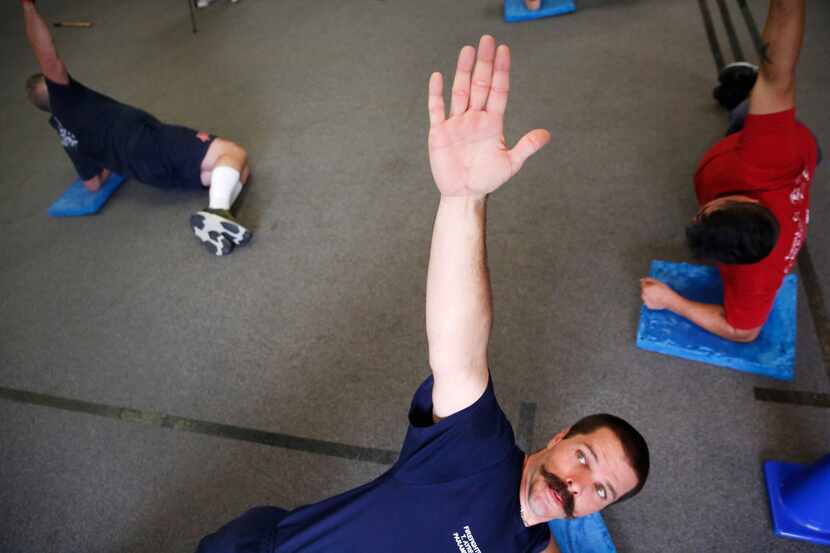 Addison firefighter/paramedic Troy Ayres holds a pose at REACT gym in Addison, Texas on...