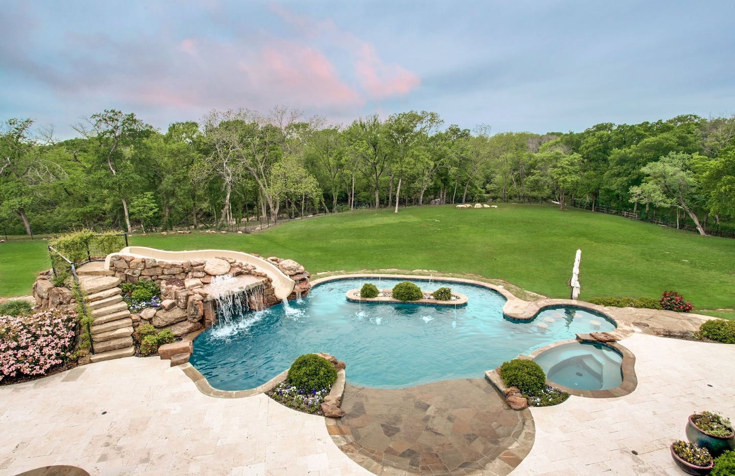 The large, beautiful pool includes a slide and waterfall.