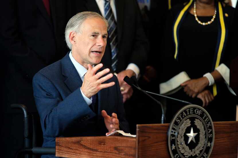 FILE - In this Friday, July 8, 2016 file photo, Texas Gov. Greg Abbott, right, responds to...