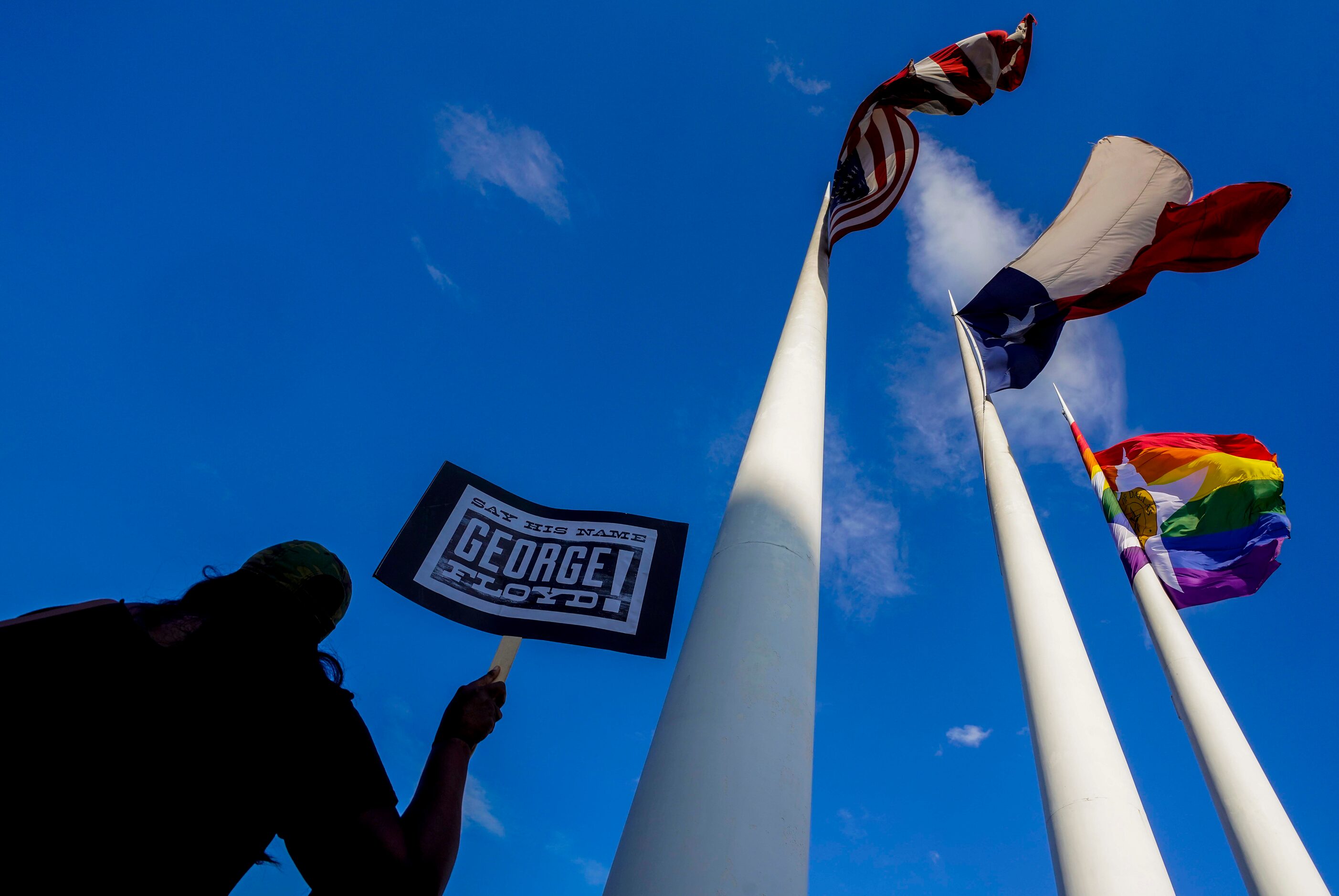 A woman holds a sign in remembrance George Floyd during a rally of the Greeks United for...