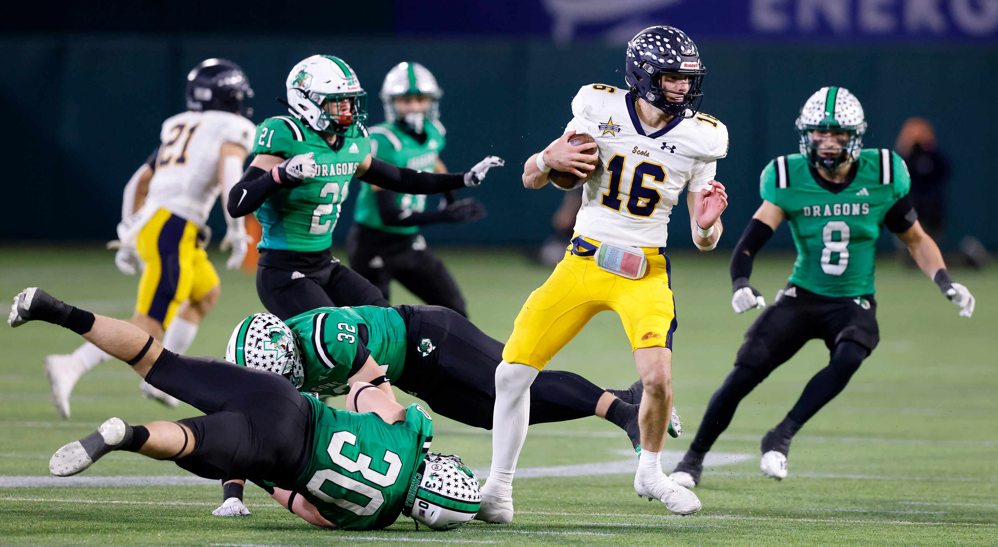 Highland Park quarterback Parker Thompson spins away from Southlake Carroll defenders...