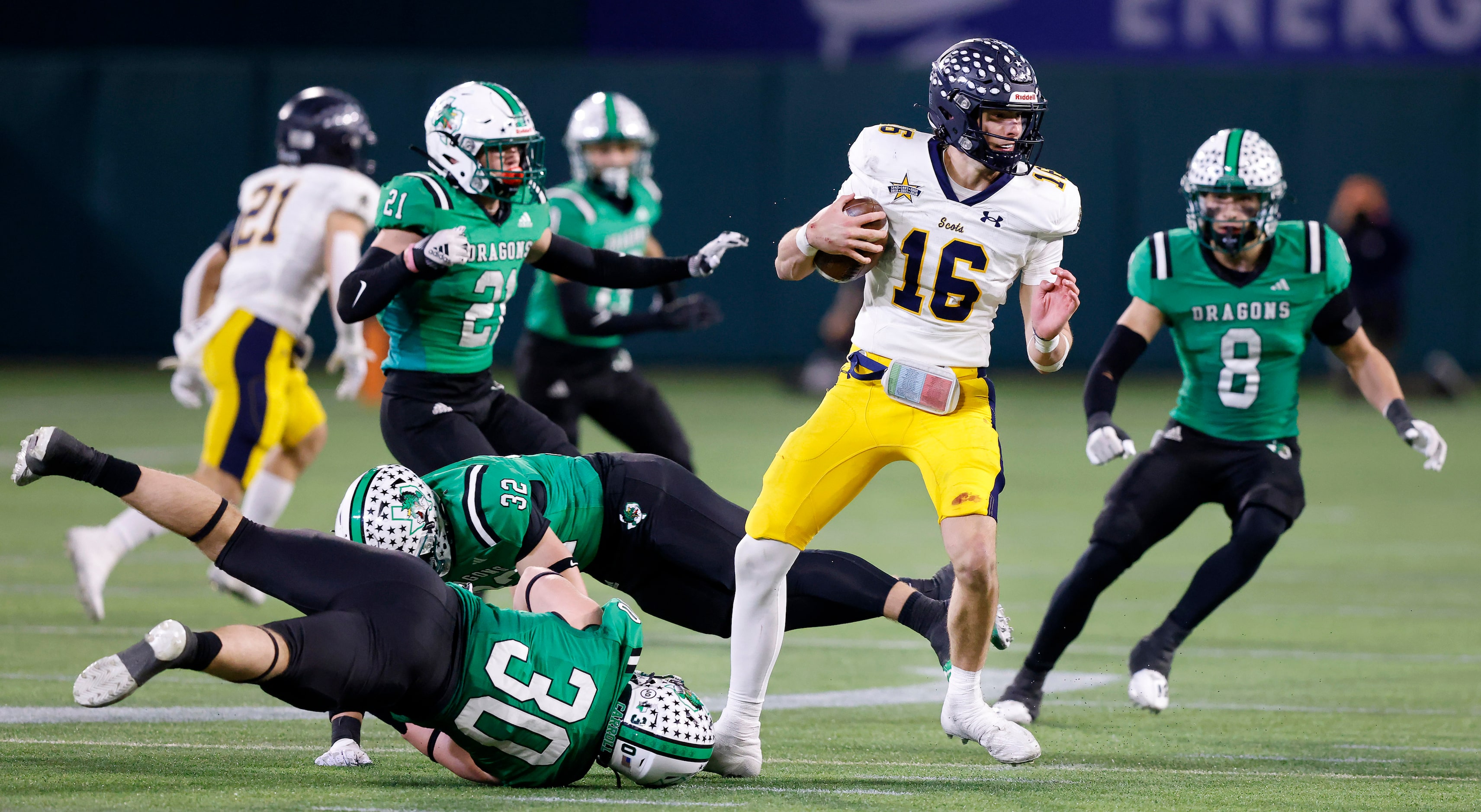 Highland Park quarterback Parker Thompson spins away from Southlake Carroll defenders...