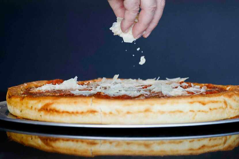 Restaurant owner Andrew Albert spreads cheese on the Chicago Bear pizza at Andrew's American...