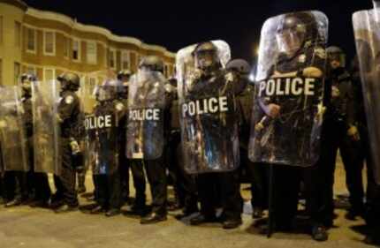  FILE - In this April 28, 2015 file photo, police stand in formation as a curfew approache...