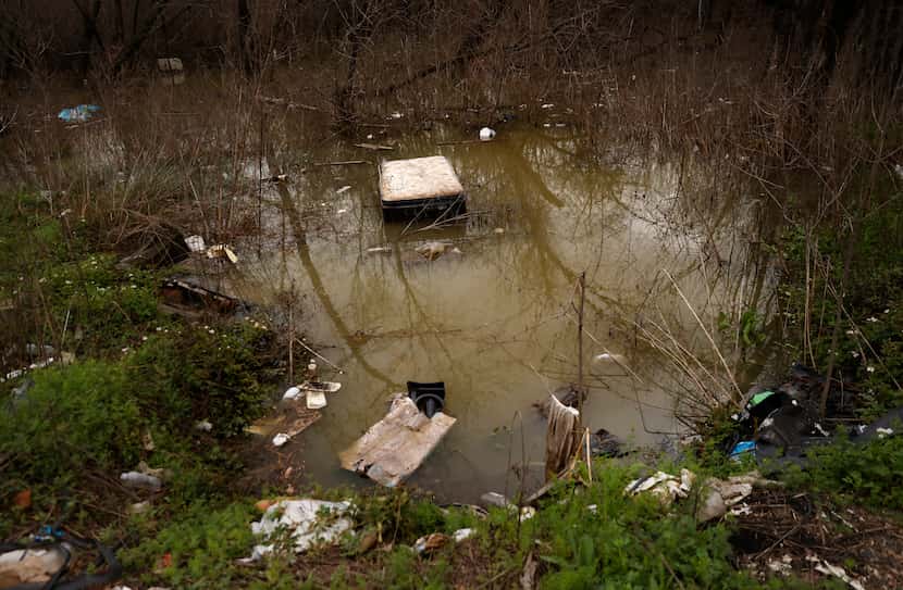 Not far from several homeless encampments on the Elm Fork, a waterlogged mattress was among...