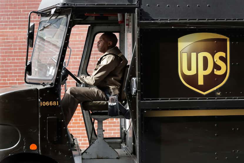 In this Tuesday, May 9, 2017, photo, a UPS driver takes his truck on a delivery route, in...