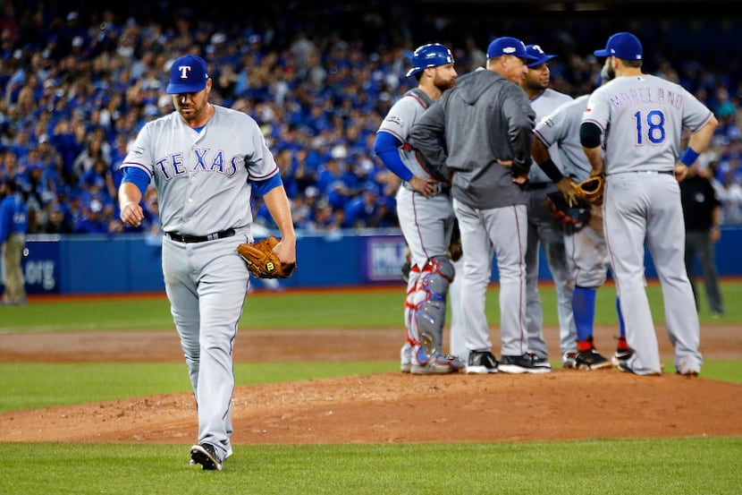 Texas Rangers starting pitcher Colby Lewis (48) walks off the field after being pulled by...