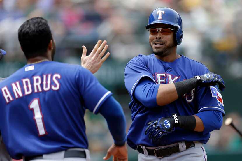 Texas Rangers' Nelson Cruz, right, celebrates with Elvis Andrus (1) after hitting a...