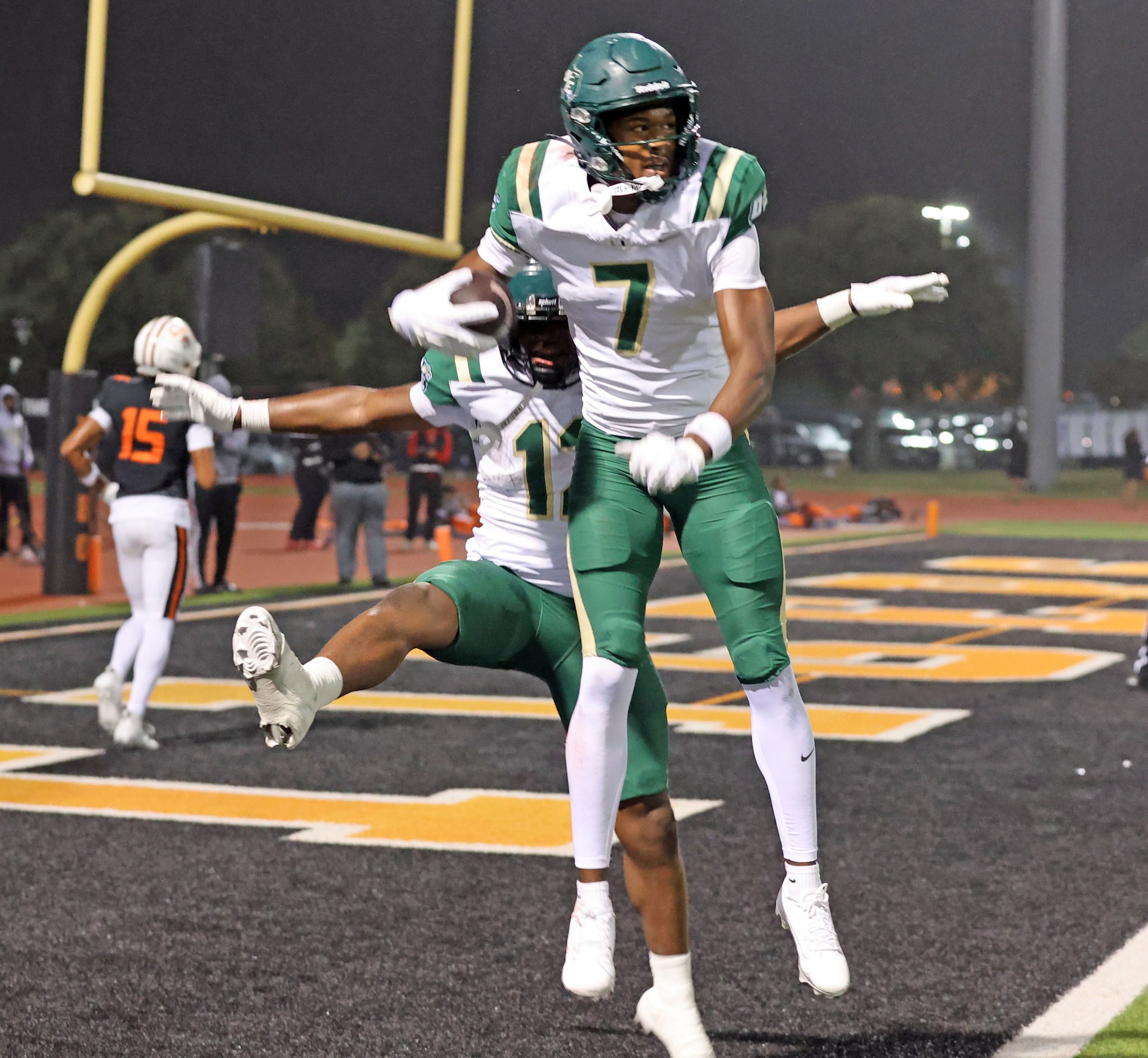 DeSoto High receiver Ethan Feaster (7) celebrates with a teammate in the end zone after...