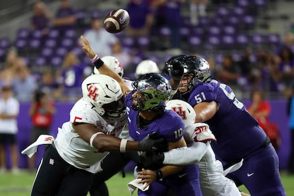 TCU quarterback Josh Hoover (10) loses the ball as he is hit by Houston defensive linemen...