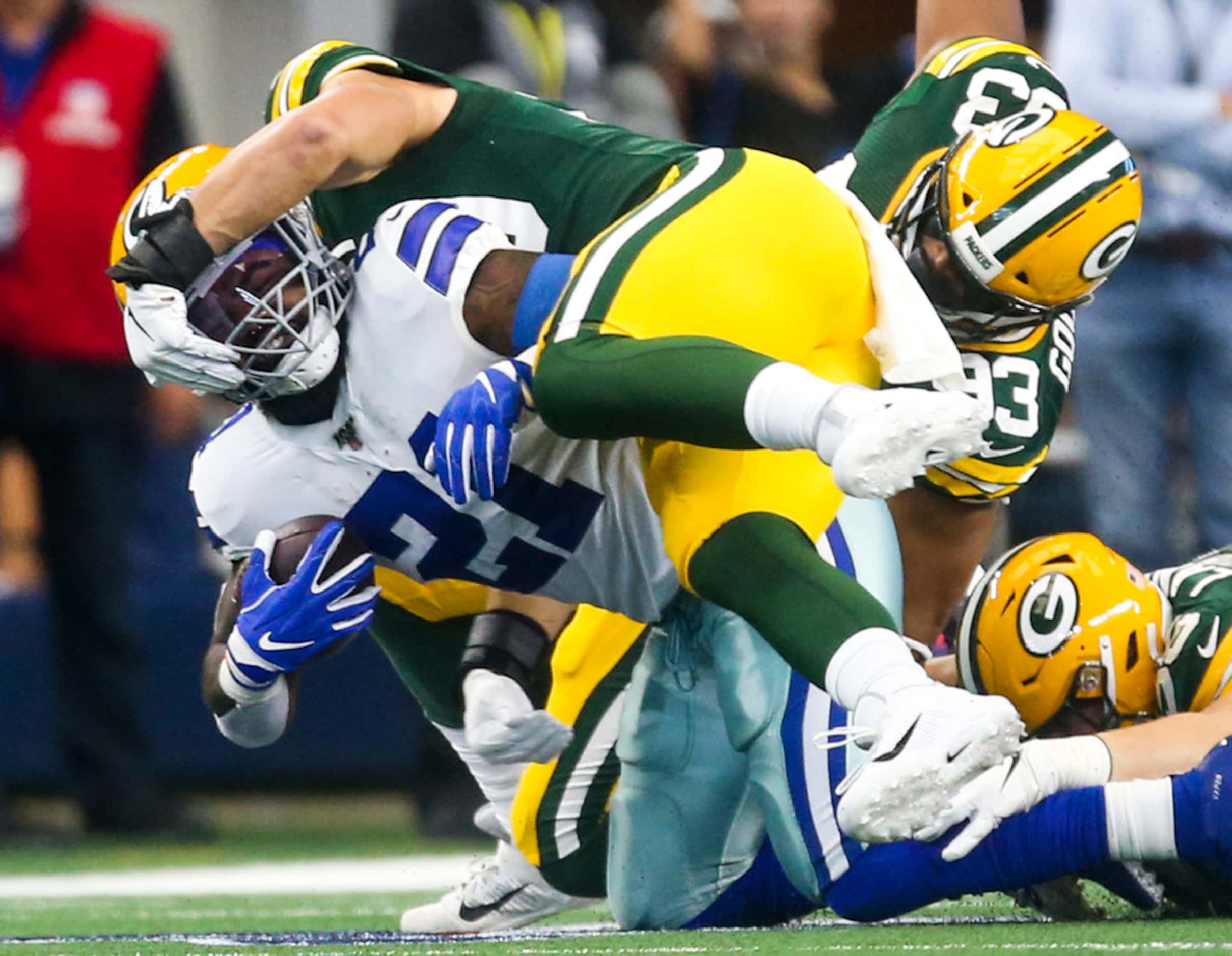 Dallas Cowboys running back Ezekiel Elliott (21) is taken down by Green Bay Packers inside...