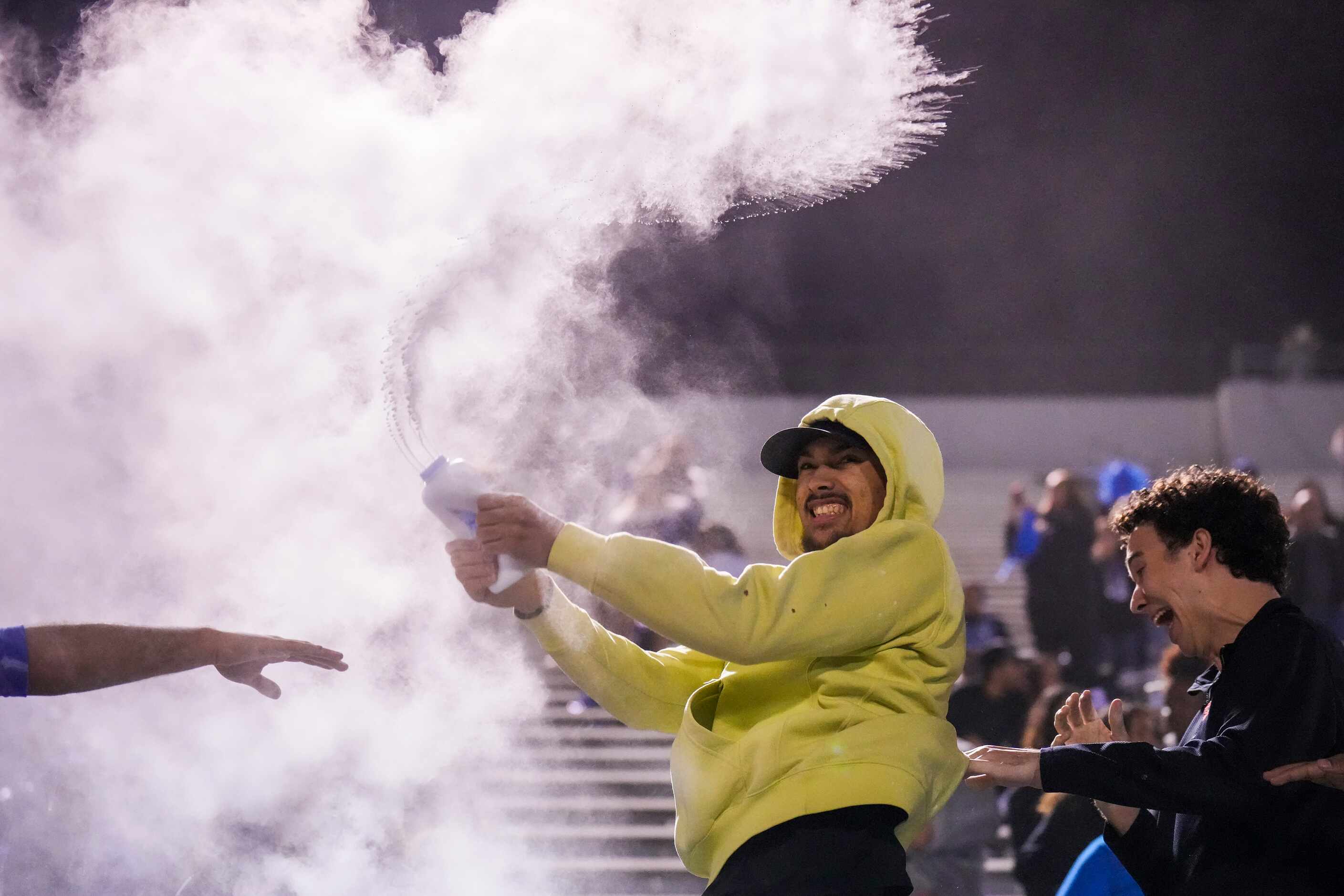 Baby powder flies in the Mansfield Summit student section after a touchdown by running back...