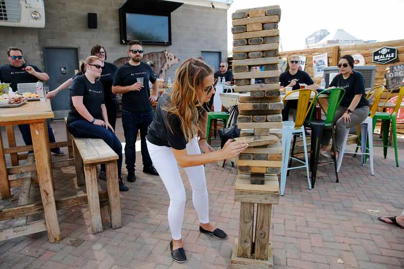 Emily Schroeder carefully removed a block of wood as she competed in a game of Jenga during...