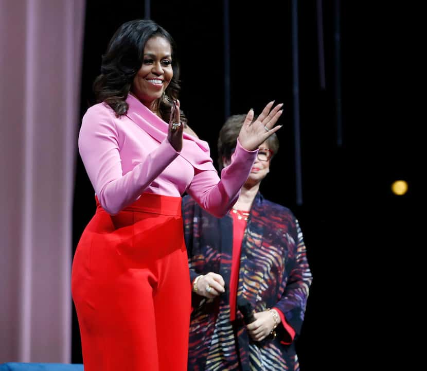 Former first lady Michelle Obama waves to the crowd as she makes her way on the stage during...