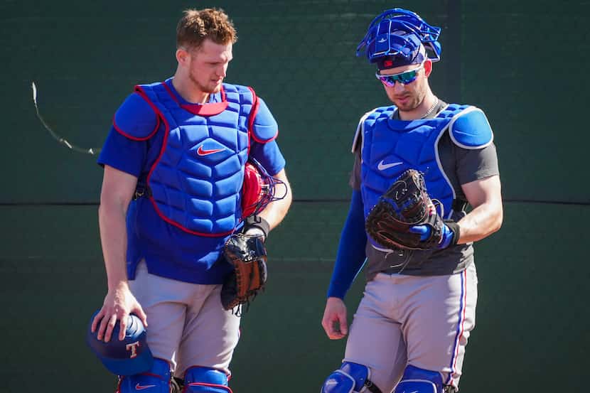 Texas Rangers catchers Sam Huff (right) and Mitch Garver compate mitts between defensive...