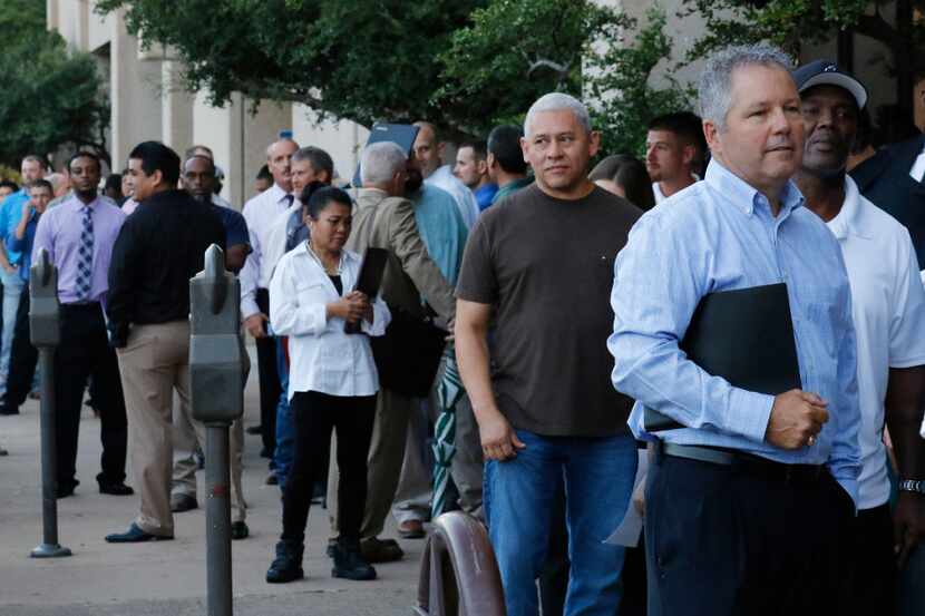 Tim Lashombe (right) of Haslet waits in a long line to apply for manufacturing positions for...